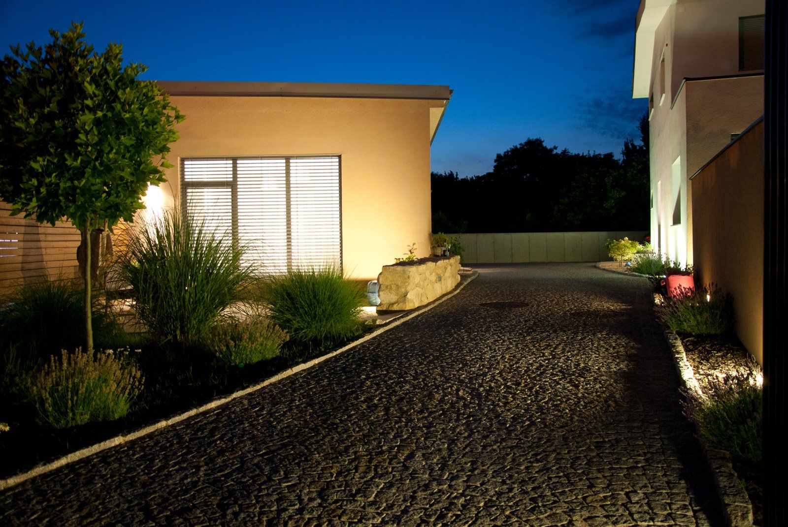 Saliterei Ferienhaus am Abend mit beleuchtetem Weg und Garten